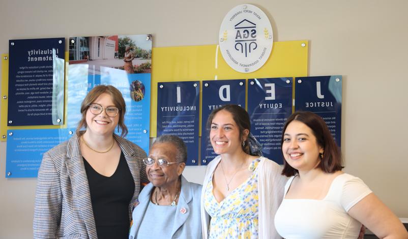 Students and university officials posing in front of the JEDI room sign